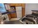 A kitchen with wood cabinets, gray counter tops, and stainless steel sink at 3433 Soho St # 101, Orlando, FL 32835