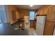Kitchen with white appliances, wooden cabinets, and a breakfast bar at 3433 Soho St # 101, Orlando, FL 32835