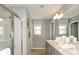 Bright bathroom featuring dual sinks, a large mirror, and a glass-enclosed shower at 404 Wayland Dr, Haines City, FL 33844