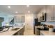 Well-equipped kitchen boasts stainless steel appliances, white stone countertops, bar seating, and gray cabinets at 404 Wayland Dr, Haines City, FL 33844