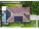 Aerial view of home featuring a pool, a screened-in enclosure, a driveway, and solar panels on the roof at 405 Carriage Way Ct, Oviedo, FL 32765