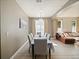 Dining area featuring hardwood floors, a chandelier, neutral paint, and a view into the living room at 405 Carriage Way Ct, Oviedo, FL 32765