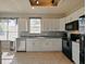Well-lit kitchen with white cabinets, granite countertops, black appliances, and stylish tile flooring at 405 Carriage Way Ct, Oviedo, FL 32765