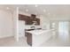 Modern kitchen with dark wood cabinets, stainless steel appliances, and a large white quartz island at 4176 Sagefield Dr, Harmony, FL 34773
