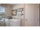 Well-lit laundry room with washer, dryer, window with blinds, and decorative wall art at 4176 Sagefield Dr, Harmony, FL 34773