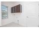 Bright laundry room features upper cabinets, tile flooring, and a window for natural light at 4176 Sagefield Dr, Harmony, FL 34773