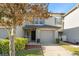Charming two-story townhouse with a gray facade, a one-car garage, and landscaped front yard at 435 Tradition Ln, Winter Springs, FL 32708