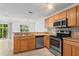 Bright kitchen features stainless steel appliances, tile backsplash, wood cabinetry and open access to the adjacent dining room at 435 Tradition Ln, Winter Springs, FL 32708