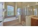 Well-lit bathroom with a soaking tub, glass enclosed shower, and vanity with ample counter space at 4536 Barrister Dr, Clermont, FL 34711