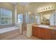 Well-lit bathroom with a soaking tub, glass enclosed shower, and vanity with ample counter space at 4536 Barrister Dr, Clermont, FL 34711