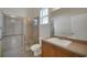 Bathroom featuring a tiled shower with a glass enclosure, a white sink, and a large mirror at 4536 Barrister Dr, Clermont, FL 34711