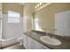 Bright bathroom with double sinks, a large mirror, and a shower-tub combination at 4536 Barrister Dr, Clermont, FL 34711
