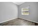 A simple bedroom with wood laminate flooring and a window for natural light at 4536 Barrister Dr, Clermont, FL 34711