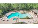 A high-angle view shows a uniquely shaped community pool, separate hot tub and ample lounge seating at 4536 Barrister Dr, Clermont, FL 34711