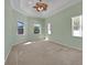 Spacious main bedroom with carpet flooring, tray ceiling, ceiling fan, and three windows for ample natural light at 4536 Barrister Dr, Clermont, FL 34711