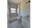 Well-lit bathroom featuring a tub with marble surround, modern fixtures, and a white vanity at 4537 Conley St, Orlando, FL 32811