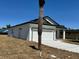 Side view of a charming white single-Gathering home with a garage, complemented by a clear blue sky at 4537 Conley St, Orlando, FL 32811