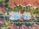 Aerial view of community pool and amenities, surrounded by lush landscaping and red tile roofs at 5578 Metrowest Blvd # 310, Orlando, FL 32811