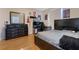 Comfortable bedroom featuring hardwood floors, a dresser, and large mirror at 5578 Metrowest Blvd # 310, Orlando, FL 32811