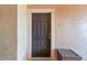 Condo entrance with dark door, door knocker, and wooden storage container at 5578 Metrowest Blvd # 310, Orlando, FL 32811
