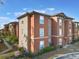 Beautiful multi-story condo building showcases a tile roof and lush landscaping, creating a peaceful community setting at 5578 Metrowest Blvd # 310, Orlando, FL 32811
