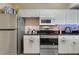 Clean kitchen features white cabinets, stainless steel appliances, and black countertop at 5578 Metrowest Blvd # 310, Orlando, FL 32811
