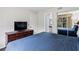 Relaxing bedroom with a blue quilted bedspread, ample storage, and TV, plus a view in the mirror at 6403 Parc Corniche Dr # 4204, Orlando, FL 32821