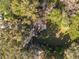 An aerial view of a home surrounded by mature trees and lush landscaping showing the roof and backyard at 719 Se 24Th St, Ocala, FL 34471