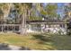 Charming single-story home featuring a blue front door, lush landscaping, and beautiful trees draped in Spanish moss at 719 Se 24Th St, Ocala, FL 34471