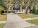 Charming single-story home featuring a blue front door, lush landscaping, and beautiful trees draped in Spanish moss at 719 Se 24Th St, Ocala, FL 34471