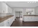 White kitchen showcasing stone countertops, white appliances, and views to living area at 719 Se 24Th St, Ocala, FL 34471