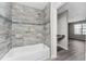 Bathroom featuring a tub with tiled walls with a blue accent stripe at 7230 Westpointe Blvd # 1222, Orlando, FL 32835