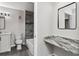 Stylish bathroom features granite countertops, gray plank flooring and tiled shower over tub at 7230 Westpointe Blvd # 1222, Orlando, FL 32835