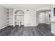 Open-concept living area featuring built-in shelving, wood floors, and a view of the entry door at 7230 Westpointe Blvd # 1222, Orlando, FL 32835