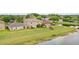 Large backyard featuring a well-maintained lawn and partial fencing with a tranquil pond view in the background at 750 Sterling Spring Rd, Orlando, FL 32828