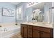Bright bathroom with double vanity, soaking tub, and a white flower arrangement on the counter at 778 Gainer Way, Winter Springs, FL 32708