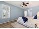Bedroom with a window with shutters, ceiling fan, light wood-look floors, and light blue paint at 778 Gainer Way, Winter Springs, FL 32708