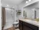 Cozy bathroom features a shower-tub combo, a wooden cabinet, and a decorative mirror at 808 Grandin St, Davenport, FL 33837