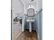 Charming powder room featuring blue wainscoting, pedestal sink, and wood-look floors at 808 Grandin St, Davenport, FL 33837