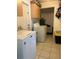 Functional laundry room with washer, dryer, storage cabinets, and neutral tiled floor at 825 Keats Ave, Orlando, FL 32809