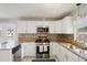 Updated kitchen showcasing stainless steel appliances, granite countertops, and modern backsplash at 825 Keats Ave, Orlando, FL 32809
