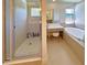 Luxurious bathroom featuring a glass shower, vanity area, and soaking tub in a soothing, neutral color palette at 827 Dennis Ave, Orlando, FL 32807