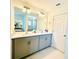 Modern bathroom with double sinks, gray cabinets, contemporary lighting, and a walk-in glass shower at 827 Dennis Ave, Orlando, FL 32807