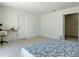 Bright bedroom with carpet, a door to another room, two closets, and a patterned comforter on the bed at 827 Dennis Ave, Orlando, FL 32807