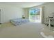 Sunlit bedroom featuring a large slider to a balcony, plush carpet, and modern work space at 827 Dennis Ave, Orlando, FL 32807