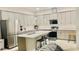 Modern kitchen with white cabinets, stainless steel appliances, and a large island with bar seating at 827 Dennis Ave, Orlando, FL 32807