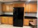Cozy kitchen with wooden cabinets and modern black refrigerator appliance at 831 N Fern Creek Ave # 101, Orlando, FL 32803