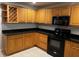 Modern kitchen with wooden cabinets, black appliances, and a built-in wine rack at 831 N Fern Creek Ave # 101, Orlando, FL 32803