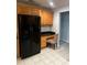Kitchen with wooden cabinets, a black refrigerator, and built-in desk at 831 N Fern Creek Ave # 101, Orlando, FL 32803
