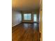 Well-lit living room with hardwood floors, a large window, and a door at 831 N Fern Creek Ave # 101, Orlando, FL 32803